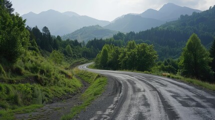 Wall Mural - Winding asphalt road through a green forest with mountains in the horizon