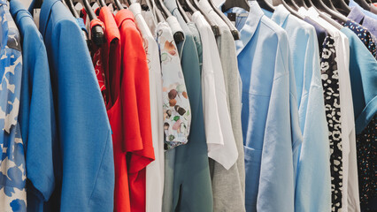 Wall Mural - A rack of clothes with a blue shirt on the top