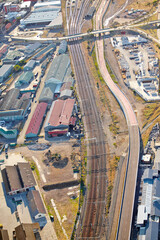 Industrial, train park and aerial view of warehouse, factory and city district development. Urban, drone and manufacturing or production street for road, shipping and transportation for cargo