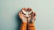 © Faith Stock - International Day of Peace. Hands holding a paper dove on a blue background with copy space.