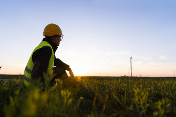 Aufkleber - Worker sits on the grass and looks at wind turbines