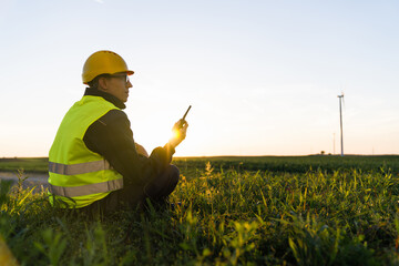 Aufkleber - Worker sits on the grass and looks at wind turbines