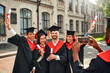 © Valerii Apetroaiei - Happy graduates celebrating and posing for photos in their academic robes outside