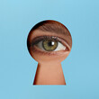 © New Africa - Woman looking through keyhole in light blue surface