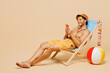 © ViDi Studio - Full body young man wear yellow shorts swimsuit hat relax rest near hotel pool sit in deckchair hold use mobile cell phone isolated on plain beige background. Summer hot vacation sea sun tan concept.