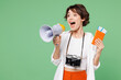 © ViDi Studio - Traveler woman wear casual clothes hold passport ticket scream in megaphone about sale isolated on plain green background Tourist travel abroad in free spare time rest getaway Air flight trip concept