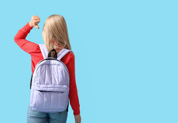 Poster - Cute schoolgirl with backpack on blue background