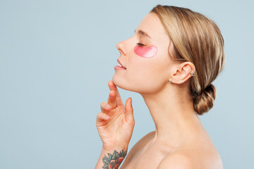 side profile view half naked topless young woman with nude make up wearing pink patch under closed e