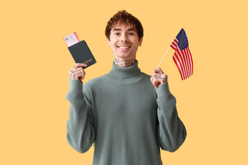 Wall Mural - Handsome young man with USA flag and passport on yellow background. Immigration concept