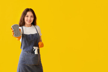 Canvas Print - Young woman with sponge on yellow background