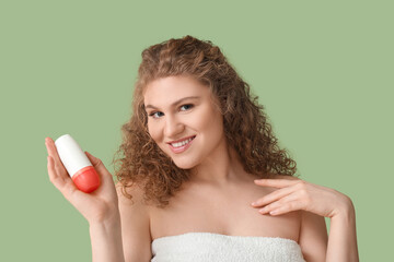 Wall Mural - Pretty young woman with deodorant on green background