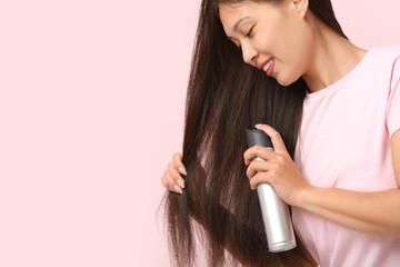 Sticker - Beautiful young happy woman applying hair spray on pink background