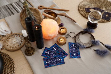 Wall Mural - Magic attributes with burning candles on table in witch's room, closeup