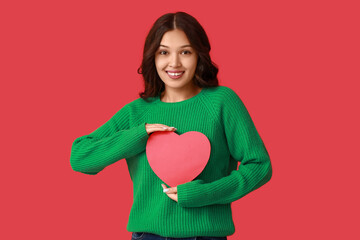 Wall Mural - Beautiful young Asian woman with red paper heart on color background. Valentine's Day celebration