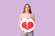© Pixel-Shot - Beautiful young displeased woman with heart dislike icon on purple background