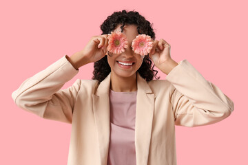 Poster - Beautiful young African-American woman with gerbera flowers on pink background. International Women's Day