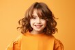 © Stocknterias - Portrait of cute little girl with curly hair on yellow background.