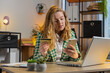 © Andrii Iemelianenko - Happy Caucasian woman using bank credit card and smartphone for online shopping payments at home office. Business transaction. Smiling girl freelancer purchases with cellphone E-banking app service.