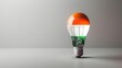 © WACHI - Light bulb painted with Indian flag colors. Symbol of innovation and patriotism. Isolated on a neutral background.