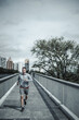 © Charnchai saeheng - A man running up on footbridge in the city center park for cardio workout.  Health and Lifestyle in big city life concept.