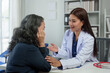 © crizzystudio - An Asian female doctor explains and encourages the struggle of life to a retired female patient who comes for treatment and therapy at a private clinic. Health concept, health insurance.