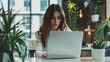 © Jaroon - A woman is sitting at a table with a laptop, creating a pleasant and relaxing atmosphere.