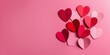 © Andrew505 - Valentine's Day flat lay featuring a stylish arrangement of red and pink paper hearts on a pink background.