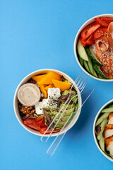 Wall Mural - Different poke bowls on blue background top view