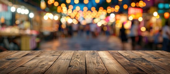 Wall Mural - Empty wood table top and blur of night market background/selective focus .For montage product display. Copy space image. Place for adding text and design