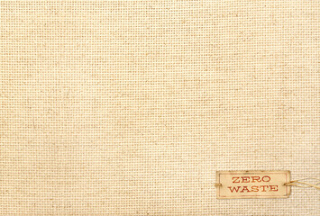 Wall Mural - Organic eco paper tag on Natural linen texture. Eco-friendly background with paper label on canvas. Sustainable development of strategy approach to zero waste, responsible consumption. Go green