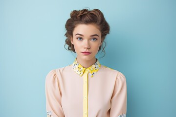 Wall Mural - A woman is wearing a yellow and white shirt and has her hair in a bun