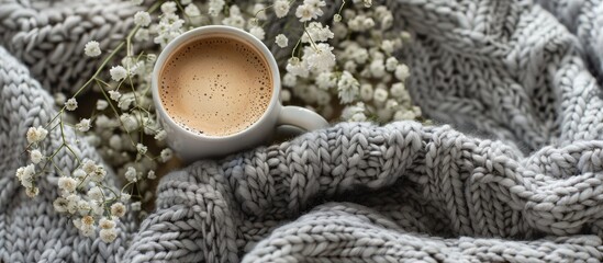 Wall Mural - Cup of coffee and gypsophila flowers on grey knitted woolen merino chunky blanket. Thick yarn. Copy space image. Place for adding text and design