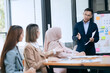 © Witoon - Professional business people taking part in a business meeting Discussing finances, strategies, and investing, they analyze charts on laptops. Demonstrate teamwork and effective communication.