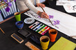 © Westend61 - Hand of woman artist painting iris flowers on white paper at home