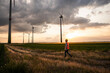 © Westend61 - Engineer walking in field with wind turbines at sunset