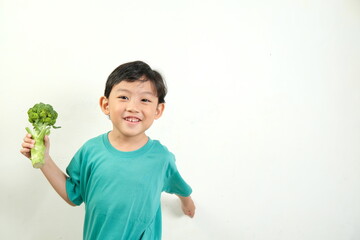 A joyful boy holds up fresh broccoli, smiling brightly against a white background. Perfect for promoting healthy eating, organic vegetables, and educational materials on healthy lifestyles.