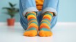 © Pro Hi-Res - Colorful striped socks on feet sitting on a white floor.