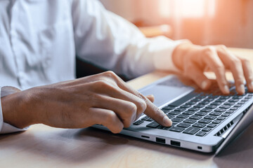 Wall Mural - businessman hand typing on computer keyboard of a laptop computer in office. business and finance co