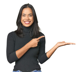 Wall Mural - simple portrait of a young latina excited holding a copy space on palm.