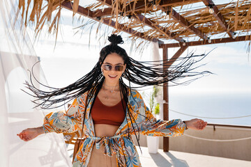 stylish pretty woman with african braids on sunny summer vacation