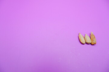 Wall Mural - peeled sunflower seeds snack isolated on a purple background