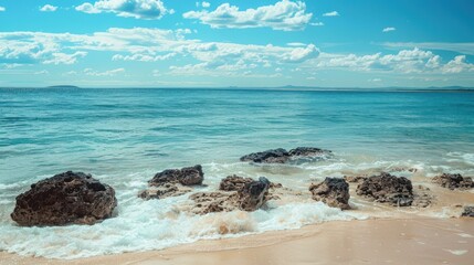 Wall Mural - Beautiful beach rocks with blue water and clear sky with waves on a sunny summer day.