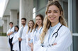 © A2Z AI  - Portrait of happy young nurse in uniform with healthcare team in background. Successful team of doctor and nurses smiling. Beautiful and satisfied healthcare worker in private clinic looking at camera