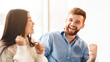 © Prostock-studio - Happy man and woman are captured laughing heartily in a professional office setting. They are sharing a moment of joy and camaraderie, possibly during a break or after a successful meeting.