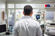 © VisualProduction - Rear view of a doctor looking at a computer screen in a clinic room