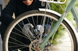 © DragonImages - Thief in black unlocking the lock on the bike and trying to steal it