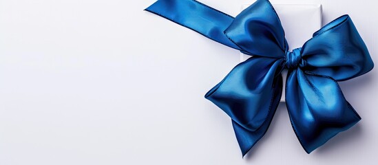 Poster - A present with a blue bow tied elegantly with a satin ribbon, set against a white backdrop with copy space image.
