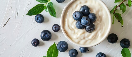 Wall Mural - Top view of a flat lounger with yogurt and fresh blueberries in the background, offering ample copy space image.