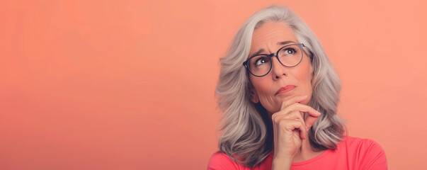 Thoughtful senior woman looking upwards in contemplation.