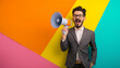 © Steven - A man in a suit with a megaphone standing against a colorful wall expressing excitement and energy perfect for announcements and marketing